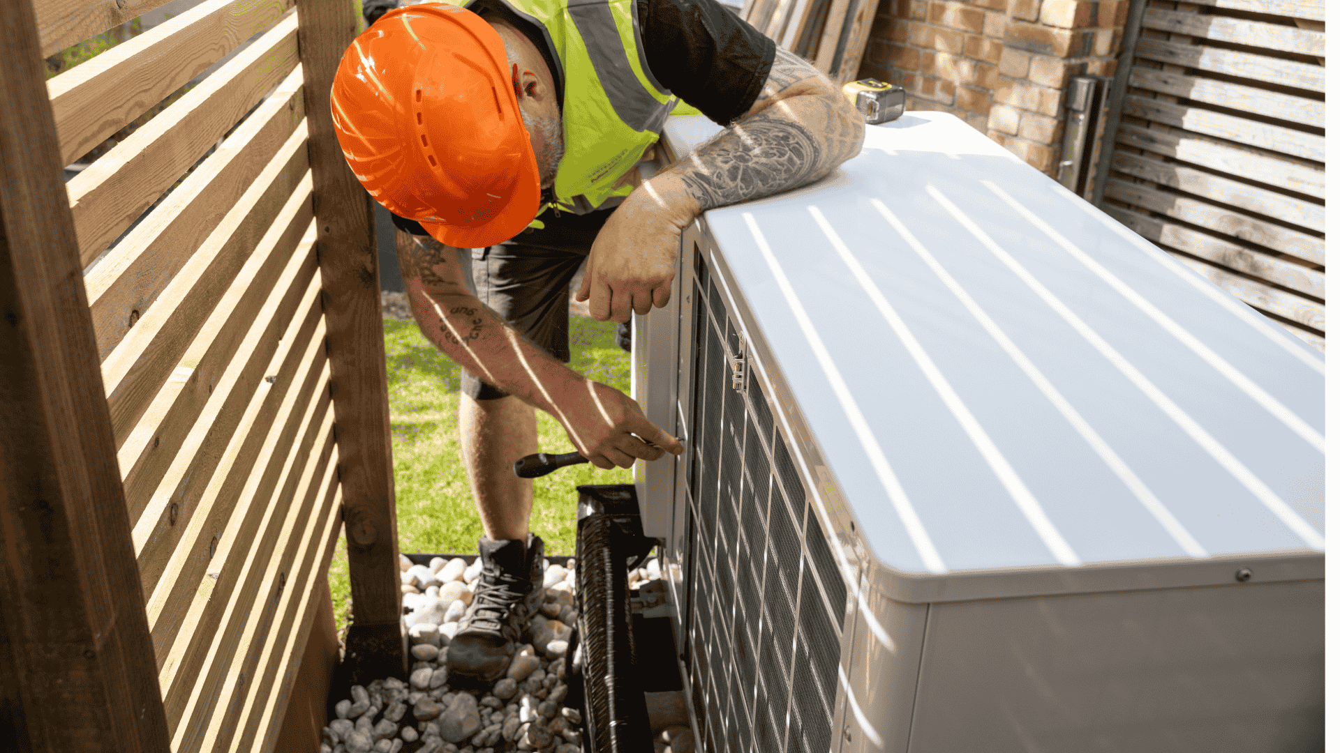 Mies avaamassa ilmalämpöpumpun ulkoyksikköä.