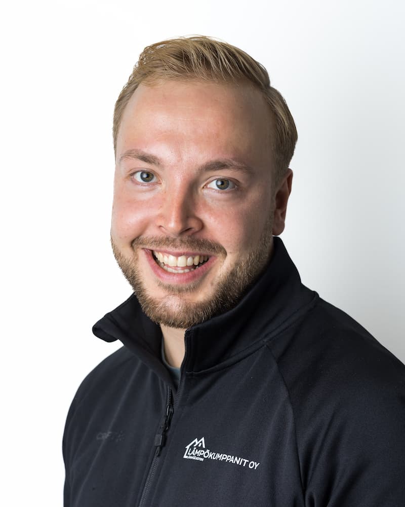Smiling man in a black zip-up jacket with a company logo on the chest, posed against a white background.